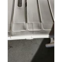 Wit hard plastic ligbed met grijs lig kussen