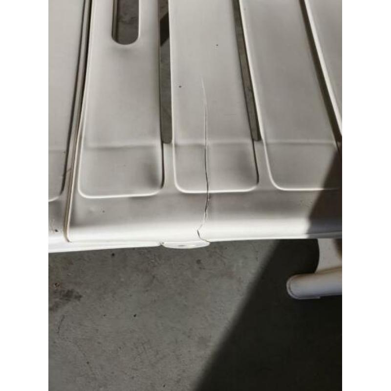 Wit hard plastic ligbed met grijs lig kussen