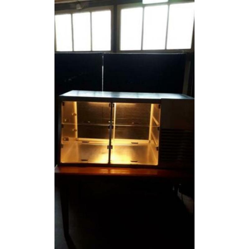 Nette, goedwerkende koelvitrine met verlichting en legbladen