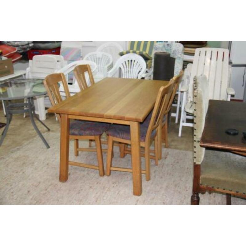 Lichte eiken eettafel met 4 stoelen met stoffen bekleding.