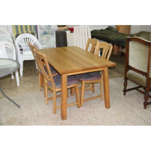 Lichte eiken eettafel met 4 stoelen met stoffen bekleding.