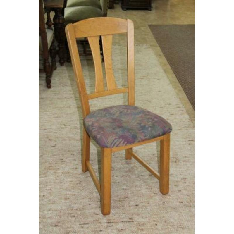 Lichte eiken eettafel met 4 stoelen met stoffen bekleding.