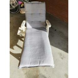 Wit hard plastic ligbed met grijs lig kussen