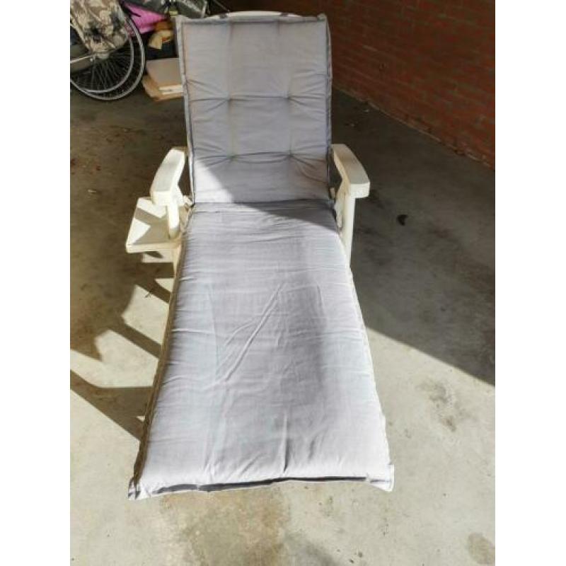 Wit hard plastic ligbed met grijs lig kussen